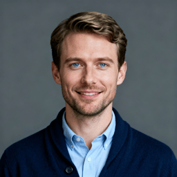 AI-generated portrait of a middle-aged man with short hair and a trimmed beard, wearing a collared shirt and sweater, posed with a neutral expression against a muted gray background with soft lighting.