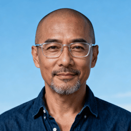 AI-generated portrait of a middle-aged man with short hair and glasses, wearing a casual shirt, posed with a relaxed expression against a soft blue background in even light.