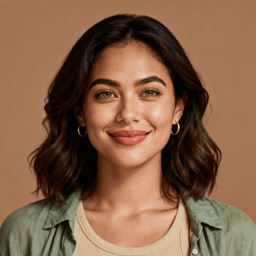 AI-generated portrait of a young woman with shoulder-length wavy hair, wearing a casual top, posed with a gentle smile against a warm neutral background in soft light.