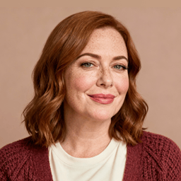 AI-generated portrait of a young woman with shoulder-length auburn hair, wearing a textured knit top, posed with a gentle smile against a warm neutral background in diffused light.