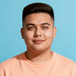 AI-generated portrait of a young man with short hair and smooth features, wearing a casual crewneck shirt, posed with a relaxed smile against a light pastel background with even lighting.
