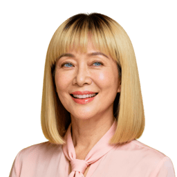 AI-generated portrait of a middle-aged woman with straight blonde hair and bangs, wearing a light blouse, posed with a warm smile against a transparent background in even lighting.