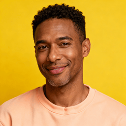 AI-generated portrait of a young man with short curly hair and smooth features, wearing a colorful shirt, posed with a relaxed smile against a yellow background in even light.