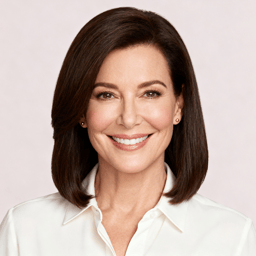 AI-generated portrait of a middle-aged woman with smooth shoulder-length hair, wearing a light blouse, posed with a gentle smile against a clean studio background in balanced lighting.
