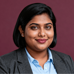 AI-generated portrait of a young woman with shoulder-length dark hair, wearing a blazer and collared shirt, posed with a warm expression against a deep maroon background in soft lighting.