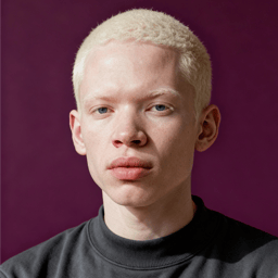 AI-generated portrait of a young person with very short light hair and smooth features, wearing a dark crewneck top, posed with a neutral expression against a deep plum background in balanced studio lighting.