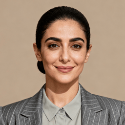 AI-generated portrait of a young woman with dark hair pulled back, wearing a tailored blazer and buttoned shirt, posed with a neutral expression against a stone-toned background in controlled studio lighting.