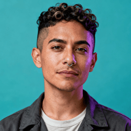 AI-generated portrait of a young person with short curly hair and a septum ring, wearing a layered shirt and jacket, posed with a neutral expression against a teal background in mixed lighting.