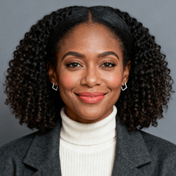 AI-generated portrait of a young woman with shoulder-length curly hair, wearing a turtleneck and blazer, posed with a friendly expression against a neutral gray background in soft studio lighting.