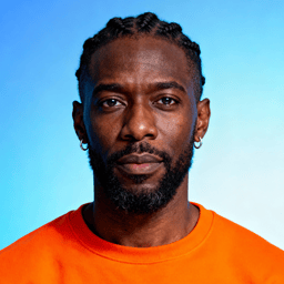 AI-generated portrait of a young man with braided hair and a short beard, wearing an orange crewneck shirt, posed with a serious expression against a blue gradient background in bright studio light.