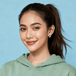 AI-generated portrait of a young woman with tied-back hair, wearing a casual hoodie, posed with a soft smile against a cool-toned background in studio light.