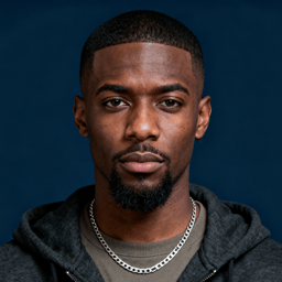 AI-generated portrait of a young man with close-cropped hair and a short boxed beard, wearing a hoodie and chain necklace, posed with a neutral expression against a deep blue background in balanced light.