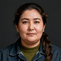 AI-generated portrait of a middle-aged woman with dark hair pulled back and light freckles, wearing a denim jacket over a knit top, posed with a composed expression against a dark background in soft diffused light.