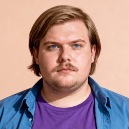 AI-generated portrait of a young man with medium-length hair and light facial hair, wearing a purple shirt and blue overshirt, posed with a neutral expression against a warm beige background in soft light.