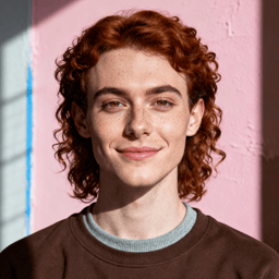 AI-generated portrait of a young person with short curly hair and freckles, wearing a simple crewneck top, posed with a calm expression against a soft pink studio background in natural light.