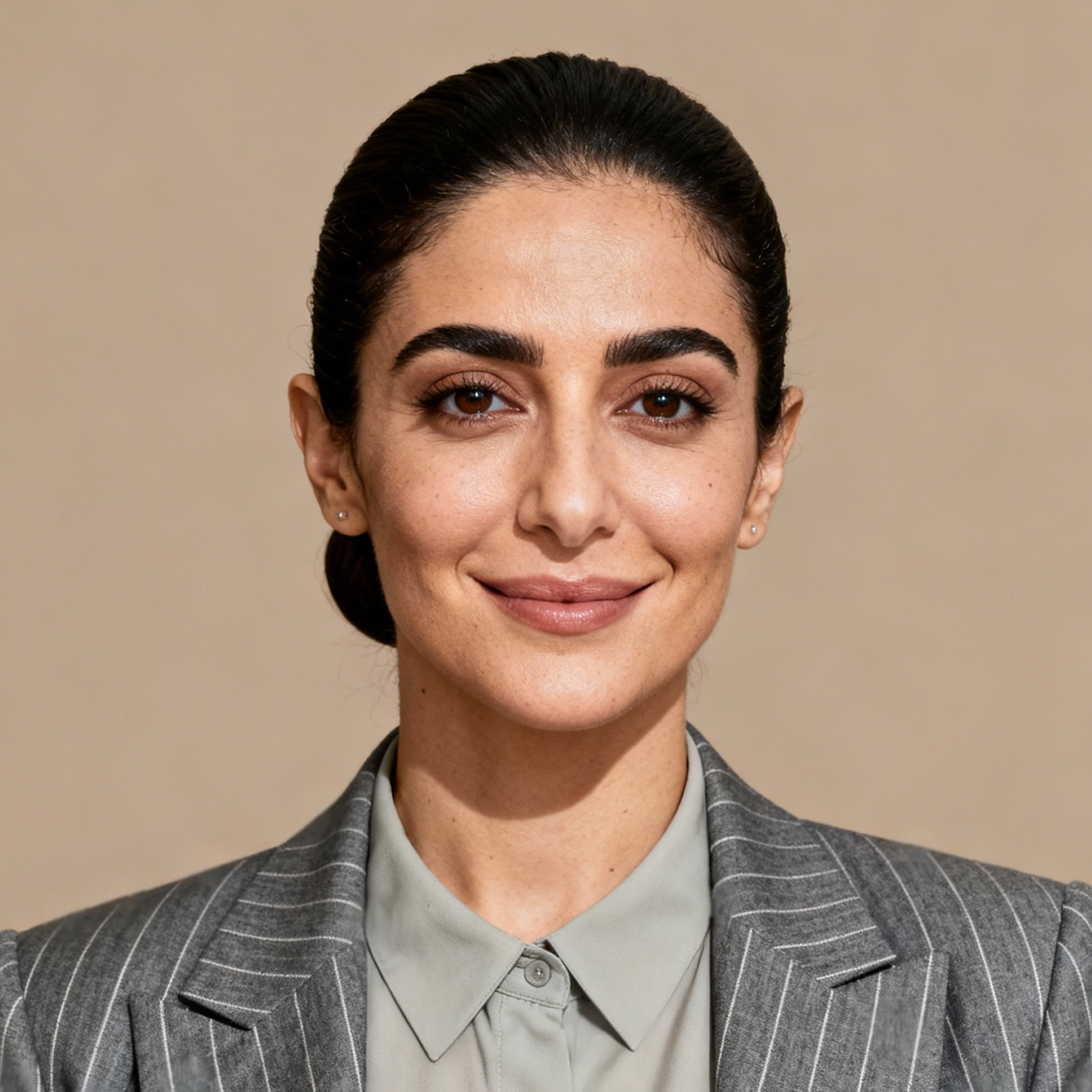 AI-generated portrait of a young woman with dark hair pulled back, wearing a tailored blazer and buttoned shirt, posed with a neutral expression against a stone-toned background in controlled studio lighting.