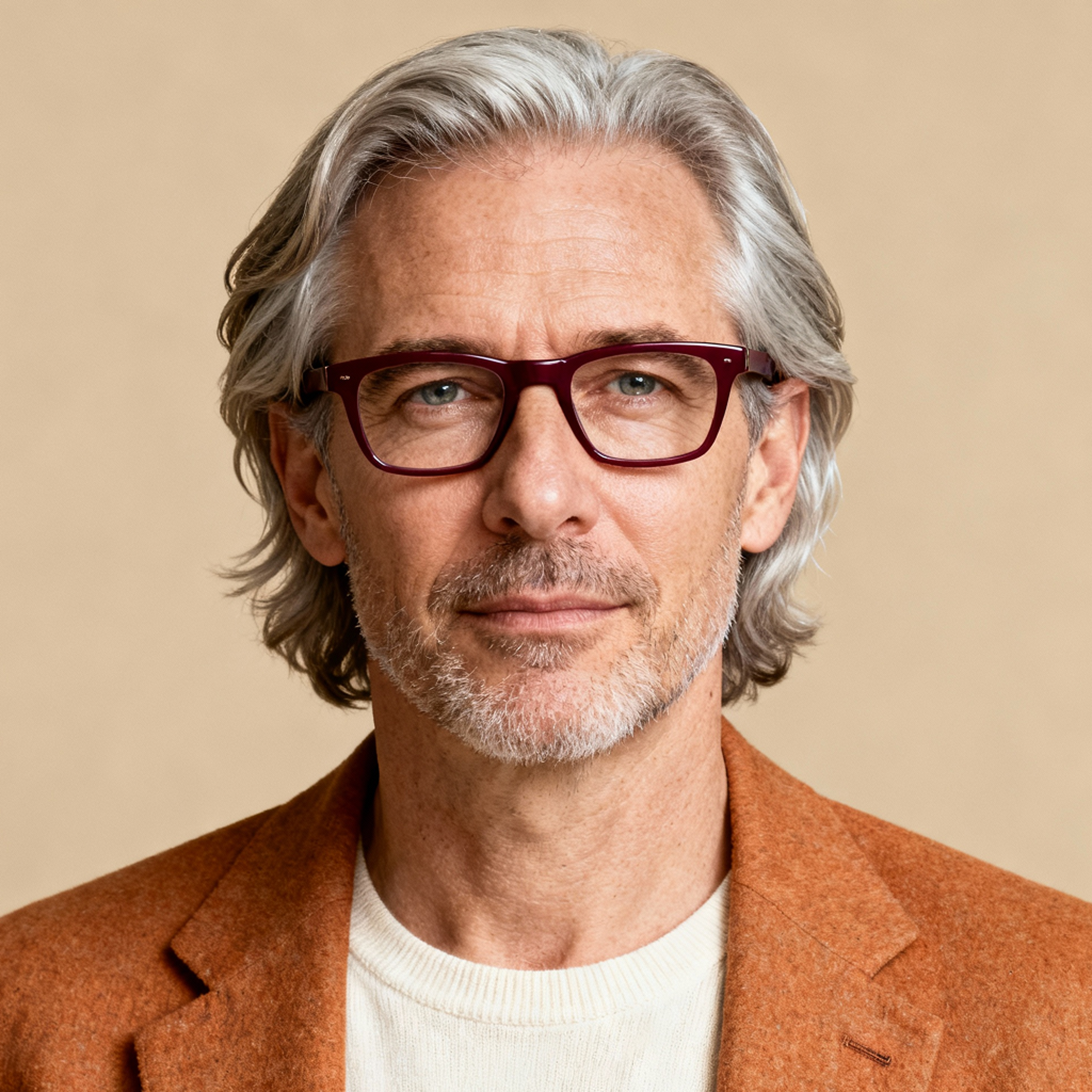 AI-generated portrait of a middle-aged man with medium-length gray hair, light stubble, and rectangular glasses, wearing a textured blazer and knit top, posed with a relaxed expression against a beige background in warm diffused light.