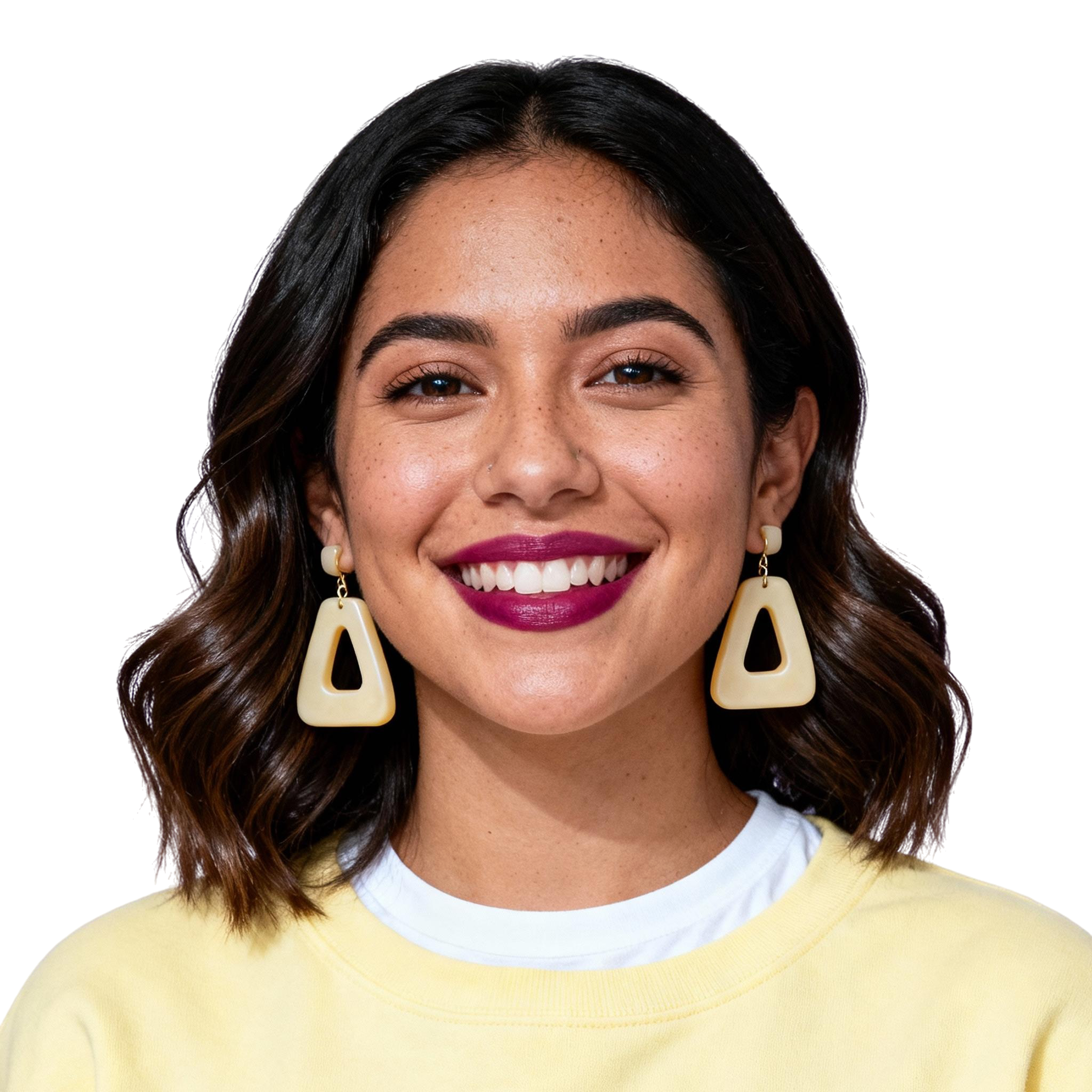 AI-generated portrait of a young woman with shoulder-length wavy hair and bold earrings, wearing a light sweater over a shirt, posed with a smiling expression against a transparent background in diffused studio light.