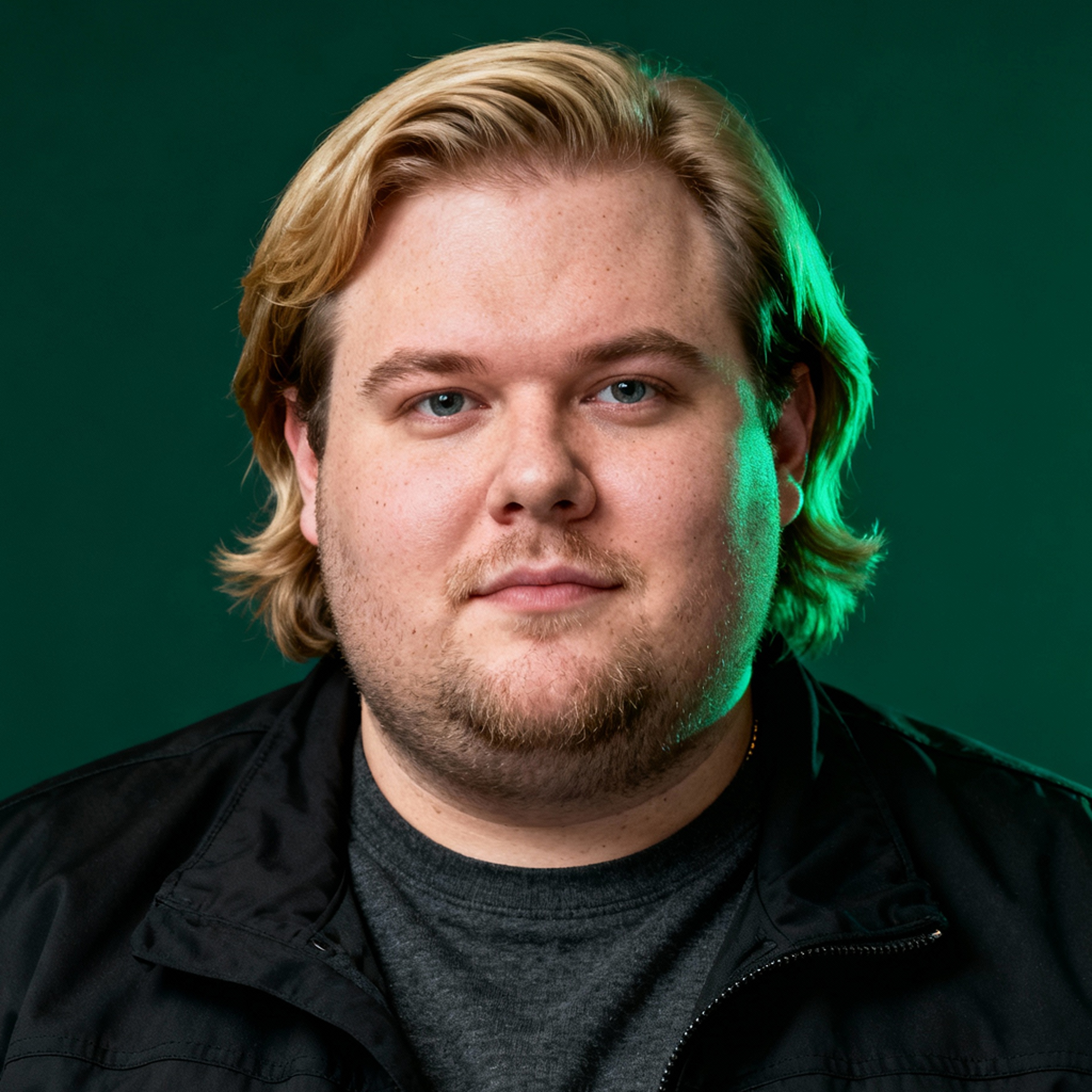 AI-generated portrait of a young man with medium-length blond hair and light facial hair, wearing a casual jacket over a t-shirt, posed with a neutral expression against a dark green background in cool studio lighting.